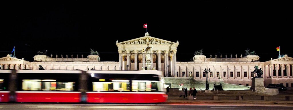 Parlament Wien - Ansicht bei Nacht mit vorbeifahrender Bim - www.wien-erleben.com